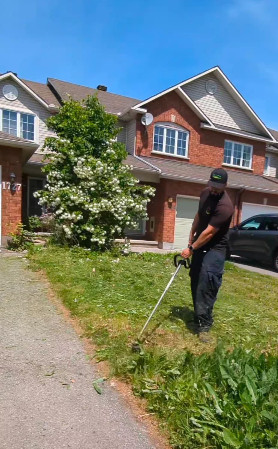 Adel precision line-trimming and edging a front yard lawn in an Ottawa residential neighborhood